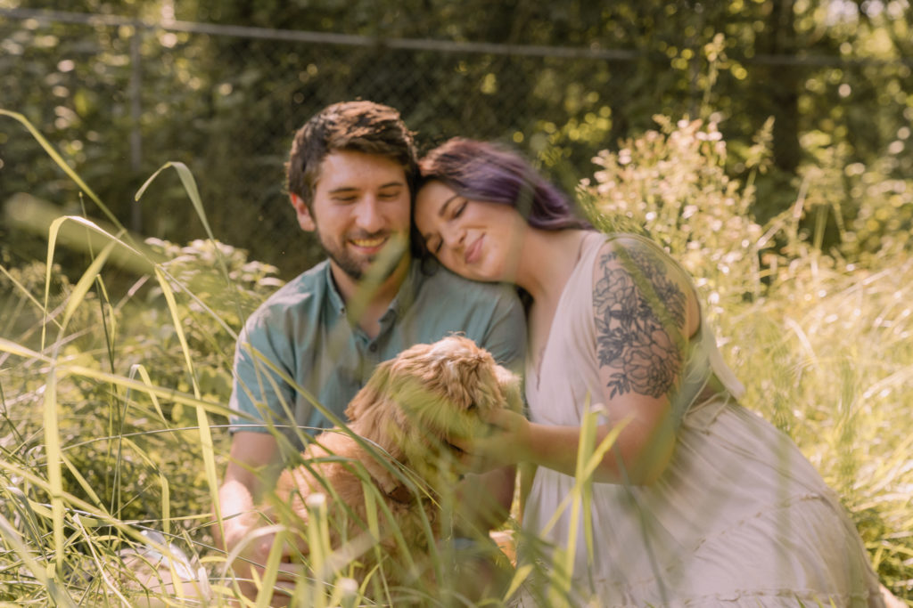 Couple in sunlit field with dog. Dog Photography tips from PA Family photographer.