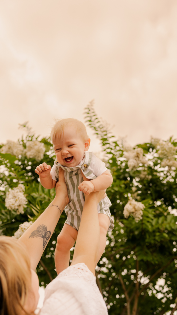 Outdoor mom holding the baby up in flowers photo ideas in  Chambersburg, PA